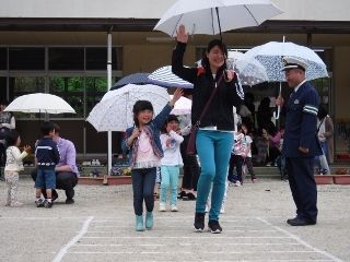 年長さんは、外で小雨が降る中、実際に傘を差し、横断歩道の渡り方の指導を受けました